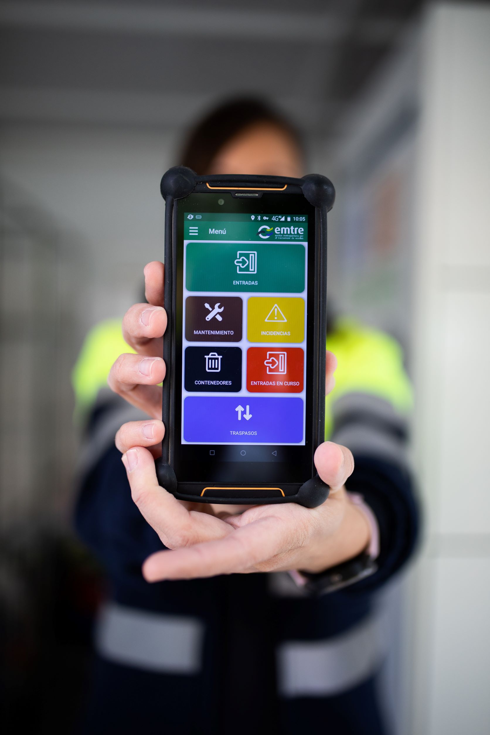 Chica sujetando un móvil y enseñando la app de Emtre